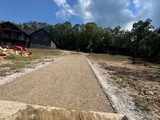 Gravel driveway prepared beside a barn-style building